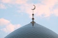 The symbol of Islam is a golden crescent moon on top of the mosque minaret. Blue evening or morning sky with clouds. Royalty Free Stock Photo