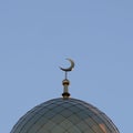 The symbol of Islam is a golden crescent moon on top of the mosque minaret. Blue evening or morning sky. A square picture. Royalty Free Stock Photo