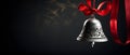 A silver bell with a red bow