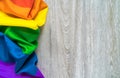 The symbol of the LGBT community is a gay pride rainbow on a wooden background.