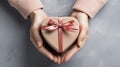 Symbol of love. Close-up on female hands holding a heart-shaped gift for valentine's day, birthday, mother's day Royalty Free Stock Photo