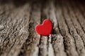 Symbol of love. Miniature red hearth shape on the old wood plank