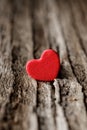 Symbol of love. Miniature red hearth shape on the old wood plank