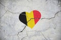 The symbol of the national flag of Belgium in the form of a heart on a cracked concrete wall Royalty Free Stock Photo