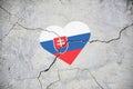 The symbol of the national flag of Slovakia in the form of a heart on a cracked concrete wall Royalty Free Stock Photo