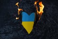 symbol of national flag of Ukraine burns on a black background. Love Ukraine concept or war concept.