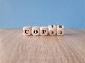 Symbol for the next climate conference. Turned cubes and changes the expression COP27 to COP28. Beautiful Blue background, wooden Royalty Free Stock Photo