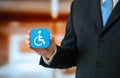 A symbol of a person with a disability or limited mobility in the hand of an official Royalty Free Stock Photo