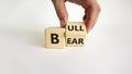 Symbol for a positive trend at the stock market. Businessman hand turns a cube and changes the word `bear` to `bull`. Beautifu Royalty Free Stock Photo