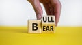 Symbol for a positive trend at the stock market. Businessman hand turns a cube and changes the word `bear` to `bull`. Beautifu Royalty Free Stock Photo