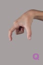 Symbol Q in gesture language. Letter made by human hand on grey Royalty Free Stock Photo