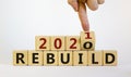 Symbol of 2021 rebuild. Male hand flips wooden cubes and changes the inscription `Rebuild 2020` to `Rebuild 2021`. Beautiful w Royalty Free Stock Photo