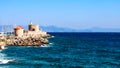 Symbol of Rhodes - windmill and fort of St. Nicholas in the port of Mandraki with sea view