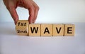 Symbol for a second wave of the corona virus. Hand turns cube and changes the expression `1st wave` to `2nd wave`. Copy space Royalty Free Stock Photo
