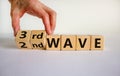 Symbol for a third wave of the corona virus. Hand turns a cube and changes the expression `2nd wave` to `3rd wave`. Copy space Royalty Free Stock Photo