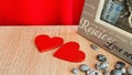 Symbol for valentine\'s day. two wooden hearts, gray pebbles, a gray photo frame