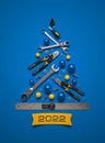 A symbolic Christmas tree made of construction tools on a blue background.