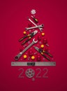 A symbolic Christmas tree made of construction tools on a red background.