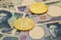 A symbolic coins of bitcoin on pile of many type japan banknotes