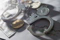 Symbolic coins of bitcoin and stack of bitcoin coins and metall handcuffs on banknotes of one hundred dollars. Exchange
