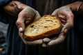 Symbolic contrast Dirty hands grip bread, depicting modern societys homeless amid capitalism