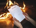 Symbolic destruction a document burning in human hands representing an irreversible end Royalty Free Stock Photo