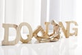 Symbolic for doping, Wooden figurine sitting in front of wooden letters Royalty Free Stock Photo