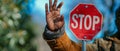 The Symbolic Gesture: A Close-Up of a Man Holding a Stop Sign on a Green Background Royalty Free Stock Photo