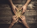 Symbolic hands connecting glowing string lights on a rustic wooden table portraying teamwork and Royalty Free Stock Photo