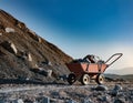 A symbolic image of an empty mining cart beside a heap of unmined rock, highlighting the potential of untouched natural resources