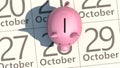 Empty piggy bank stands on calendar sheet