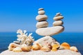 Symbolic scales of white stones, shells and coral on a background of the summer sea and blue sky Royalty Free Stock Photo