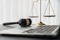 Golden balanced scale and gavel on desk with laptop in law office. equility