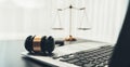 Golden balanced scale and gavel on desk with laptop in law office. equility