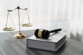 Golden balanced scale and gavel on desk with book in law office. equility