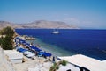 Greek islan of Symi. Crowded beach in mid summer at a beautiful bay