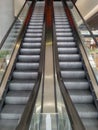 Symmetric escalator to darkness inside shopping mall