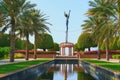 Symmetric park view to marble arabesque gazebo,fountain and elaborate girl sculpture -tightrope walker on hula hoop among palms