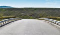 Symmetric picture along the empty bridge on the asphalt road