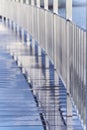 Symmetric straight lines. Reflection of chrome railing in the wet surface of the bridge after rain.