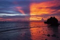 Symmetric sunset on the shore with reflection in sea water