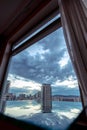 Symmetric vertical shot of the modern buildings and fluffy clouds reflecting on the window