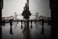 Symmetric view of people with umbrellas reflecting on the window