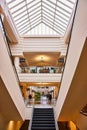 Symmetrical architecture of two staircases going up while middle goes down and mall behind