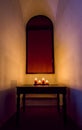 A candle lit niche in an ancient building in Padua