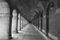 Symmetrical corridor with arches and columns of the royal palace of Aranjuez in black and white. Royalty Free Stock Photo