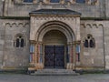 Symmetrical front view of decorated door of historic church Herz-Jesu-Kirche with stone columns.