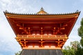 Symmetrical front view of traditional orange wooden Syoro Pagoda with carved roof in Ninna-ij Temple in Kyoto, Japan.