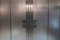 Symmetrical metal elevator doors with buttons to go up or down Royalty Free Stock Photo