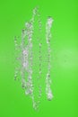 Symmetrical pattern of stopped water droplets with transparent streams on a green background. Clash, opposition and mystical